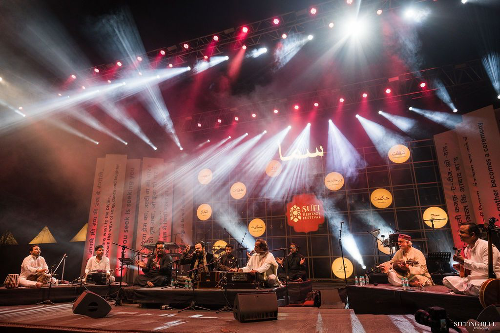A festival crowd beneath a canopy of red stage lights